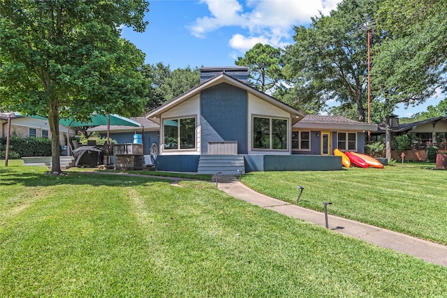 view of front of home featuring a front lawn and brick siding