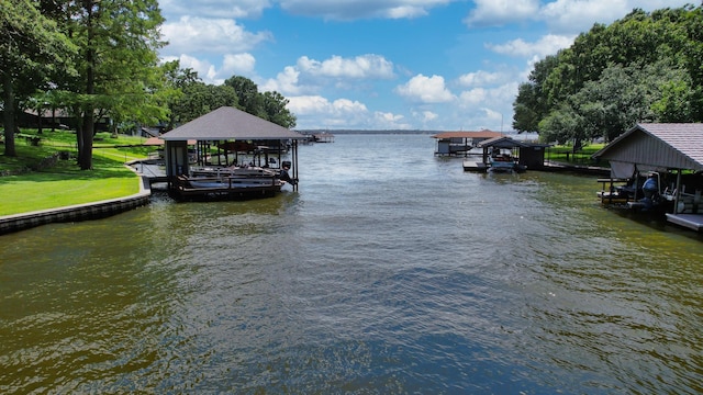 view of dock with a yard, a water view, and boat lift