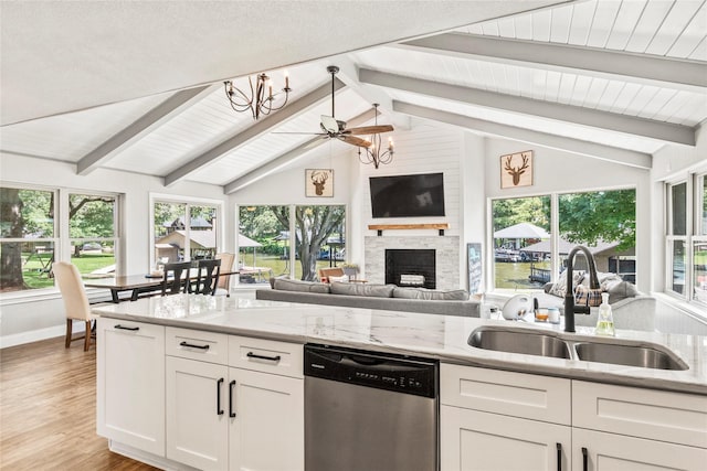 kitchen featuring lofted ceiling with beams, white cabinetry, a sink, light wood-type flooring, and dishwasher