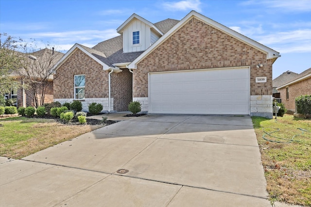 view of front of house with an attached garage, brick siding, concrete driveway, stone siding, and roof with shingles