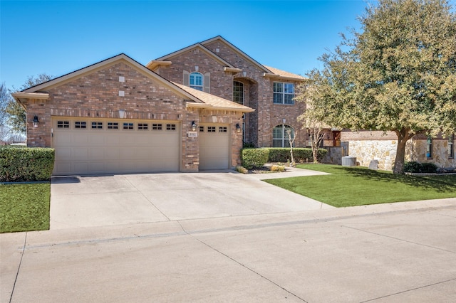 view of front of house with a front yard, brick siding, an attached garage, and driveway