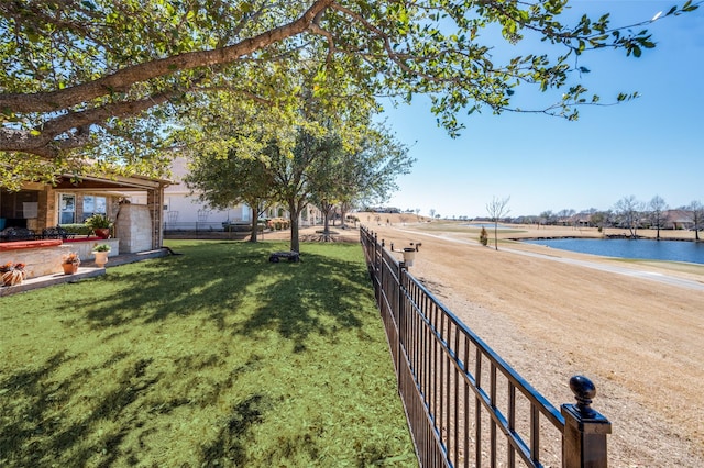 view of yard featuring a water view and fence