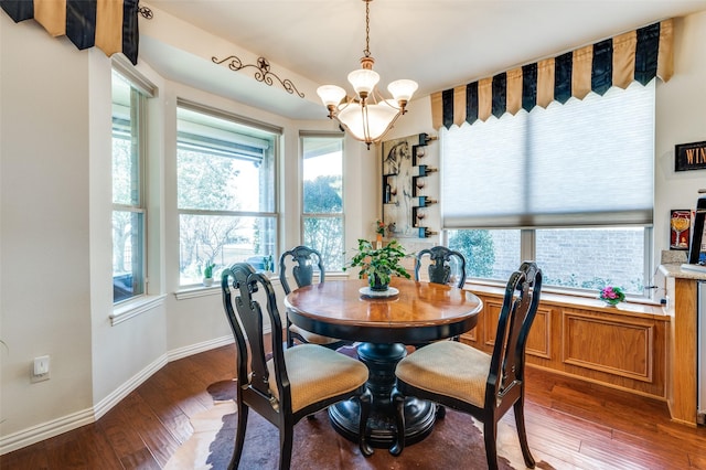 dining room featuring hardwood / wood-style floors, an inviting chandelier, and baseboards