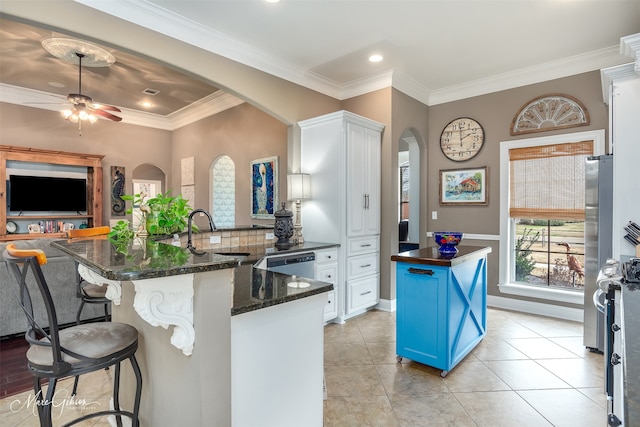 162 Captain Hm Shreve, Shreveport, LA 71115 - kitchen featuring arched walkways, a sink, blue cabinetry, a breakfast bar, and white cabinets