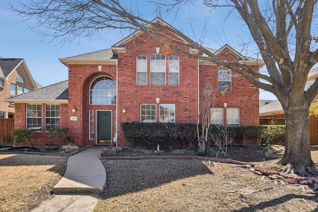 traditional-style home with brick siding and fence