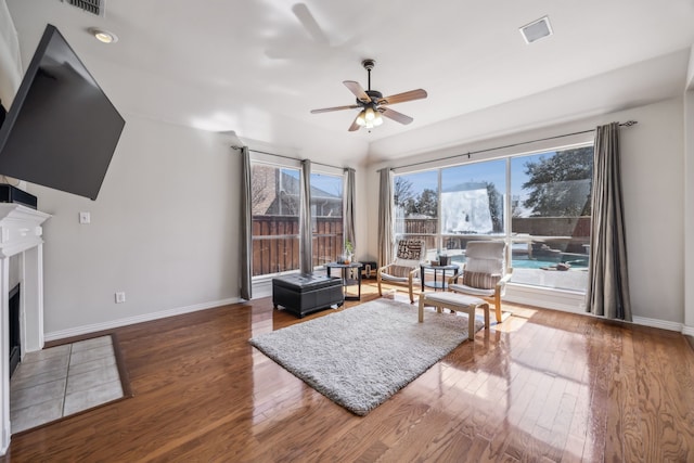 sitting room with visible vents, baseboards, a ceiling fan, a fireplace with flush hearth, and hardwood / wood-style floors