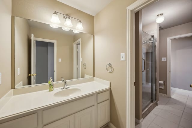 full bathroom featuring a stall shower, tile patterned flooring, vanity, and baseboards