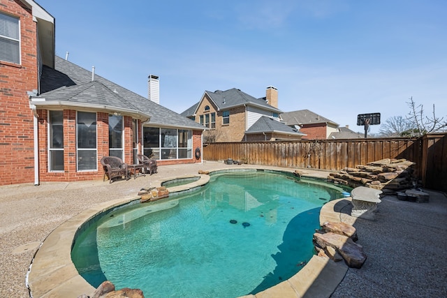 view of swimming pool featuring a sunroom, a fenced backyard, a fenced in pool, and a patio