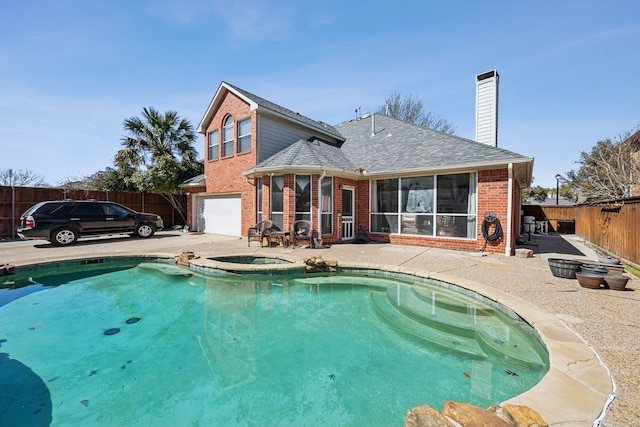 exterior space featuring brick siding, a chimney, a patio area, fence, and a garage