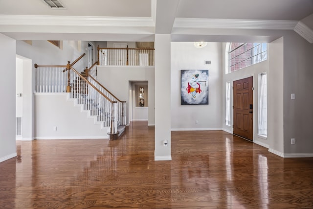 foyer featuring a high ceiling, wood finished floors, visible vents, baseboards, and stairs