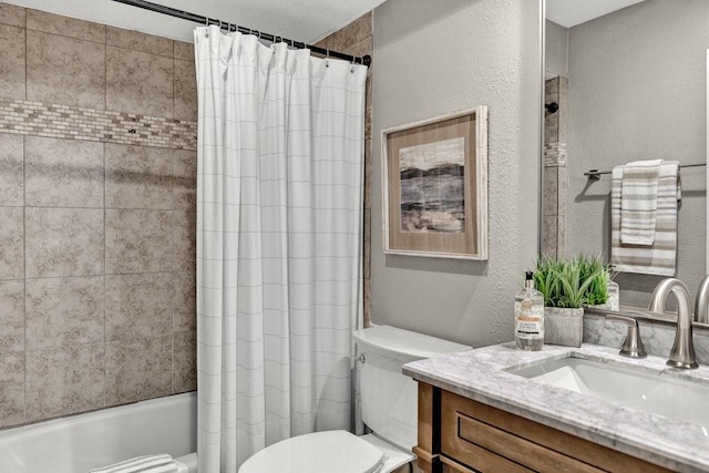 full bath with a textured wall, shower / bath combination with curtain, vanity, and toilet