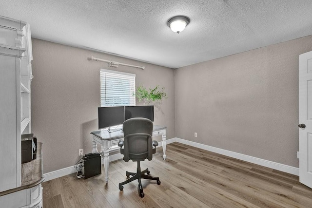 office with a textured ceiling, baseboards, and wood finished floors