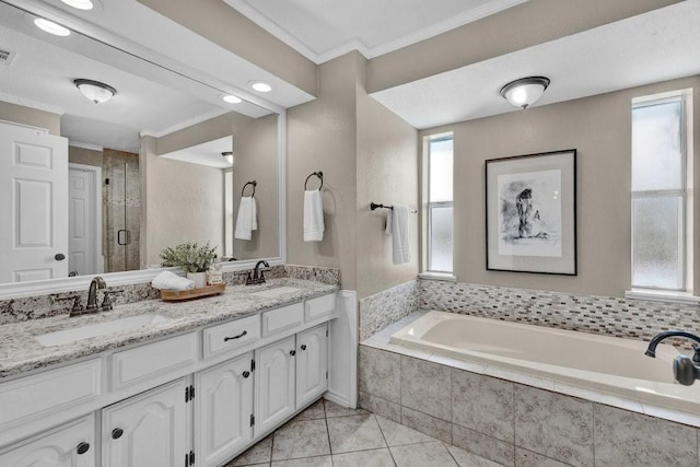 bathroom with ornamental molding, tile patterned flooring, a garden tub, and a sink