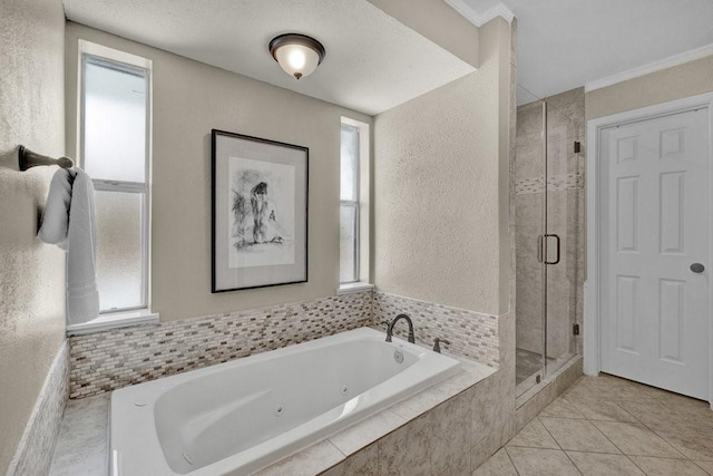 bathroom featuring a textured wall, ornamental molding, a shower stall, a tub with jets, and tile patterned floors