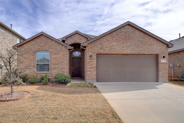 view of front of property featuring driveway, an attached garage, a front yard, and brick siding