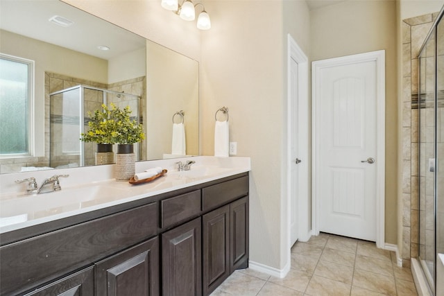 bathroom with a stall shower, a sink, and tile patterned floors