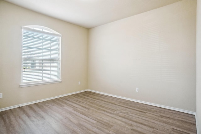 empty room with baseboards and wood finished floors