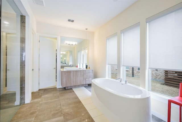 bathroom with vanity, visible vents, a stall shower, a freestanding bath, and tile patterned flooring