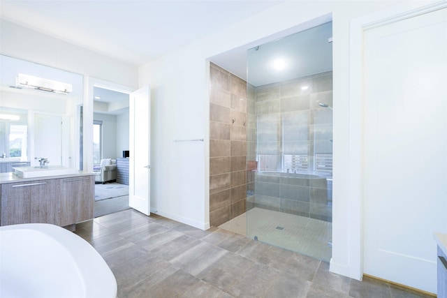 bathroom featuring baseboards, tiled shower, and vanity