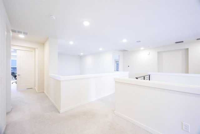 hall featuring recessed lighting, visible vents, an upstairs landing, and light colored carpet