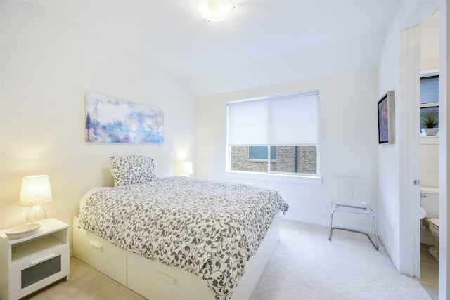 bedroom featuring light colored carpet and vaulted ceiling