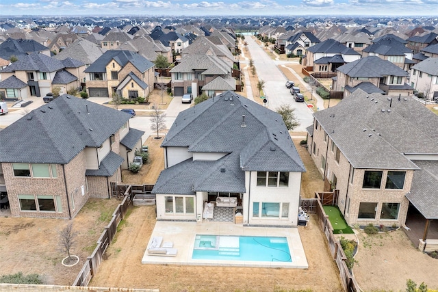 exterior space featuring a patio, a fenced backyard, a residential view, and a pool with connected hot tub