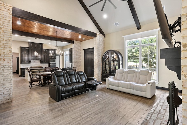 living area featuring light wood finished floors, visible vents, a ceiling fan, high vaulted ceiling, and beamed ceiling