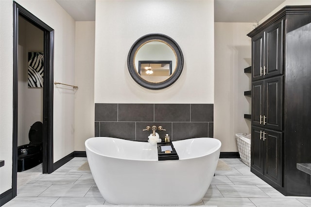 bathroom with a freestanding tub and tile walls