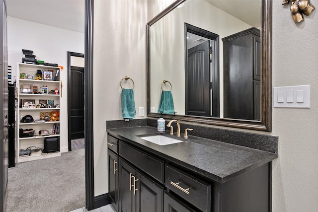 bathroom with a textured wall and vanity