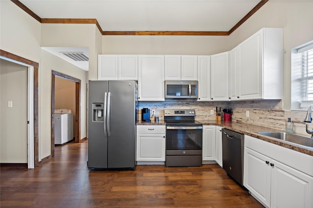 kitchen featuring washer / dryer, visible vents, a sink, stainless steel appliances, and backsplash