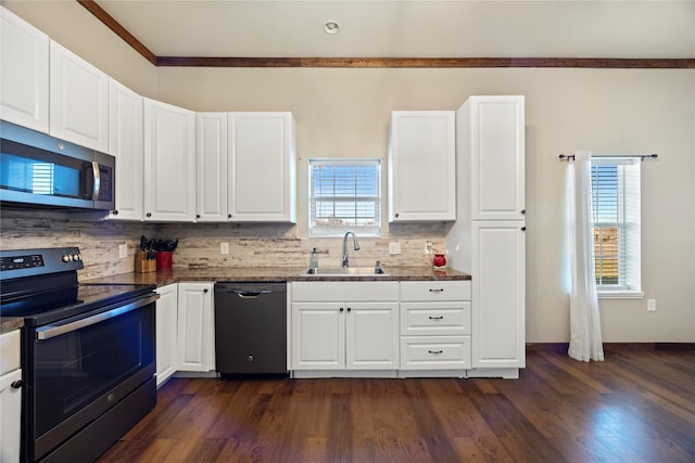 kitchen featuring dark wood-type flooring, a sink, white cabinetry, appliances with stainless steel finishes, and backsplash