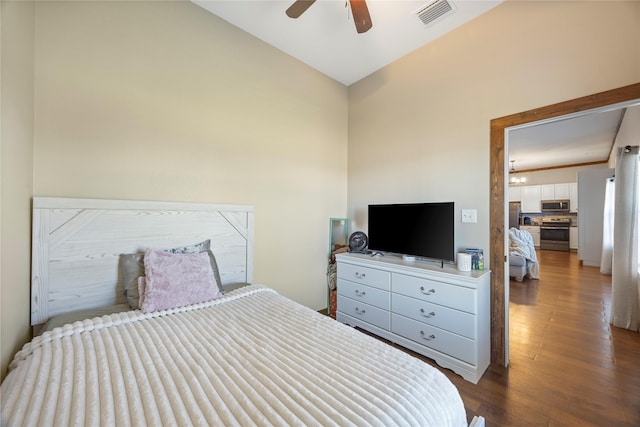 bedroom featuring dark wood-type flooring, freestanding refrigerator, visible vents, and ceiling fan