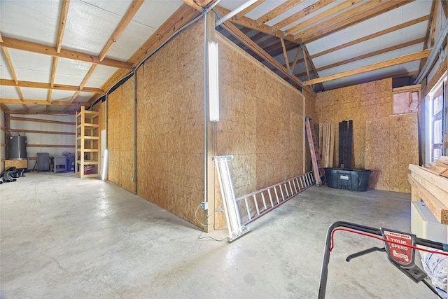 misc room with a garage, water heater, and unfinished concrete floors