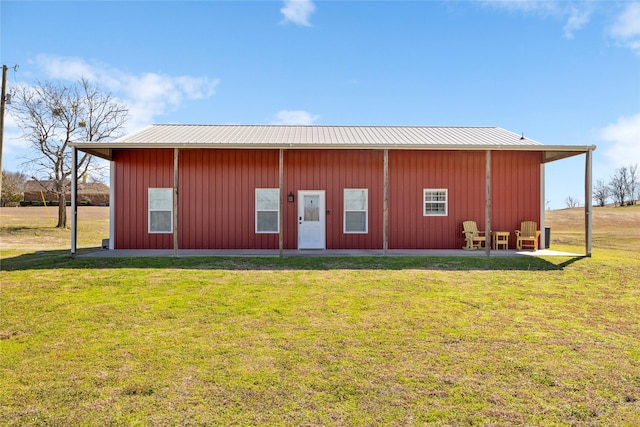 exterior space with metal roof and a yard