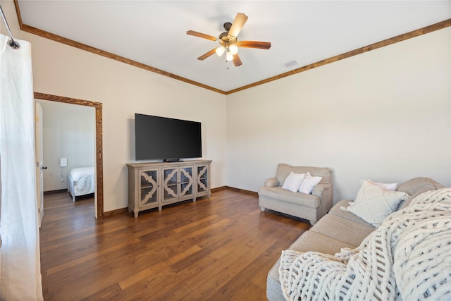 living room with a ceiling fan, ornamental molding, baseboards, and wood finished floors