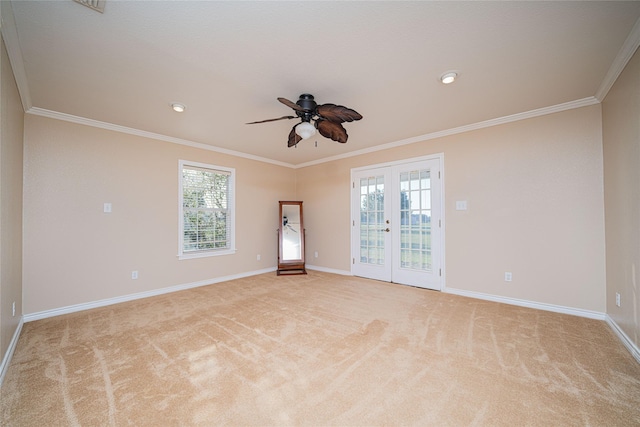 empty room with french doors, light carpet, crown molding, and baseboards