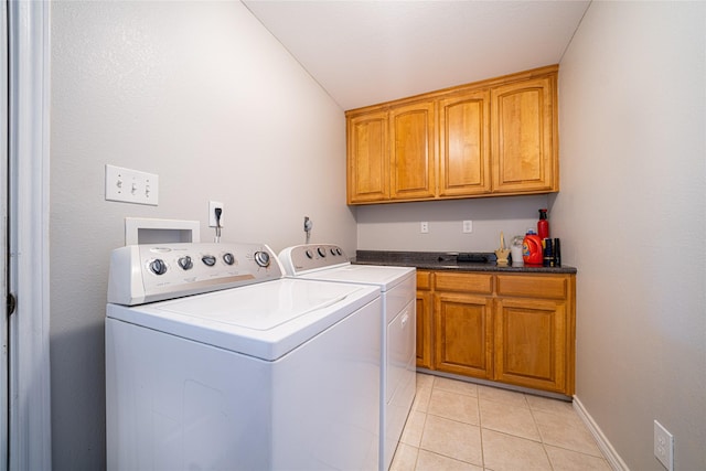 washroom with light tile patterned floors, baseboards, cabinet space, and washer and dryer