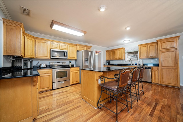 kitchen featuring dark countertops, visible vents, stainless steel appliances, and crown molding