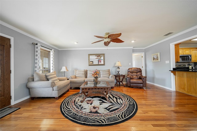 living area with light wood finished floors, visible vents, ornamental molding, ceiling fan, and baseboards