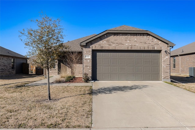 ranch-style house featuring a garage, driveway, brick siding, and central air condition unit