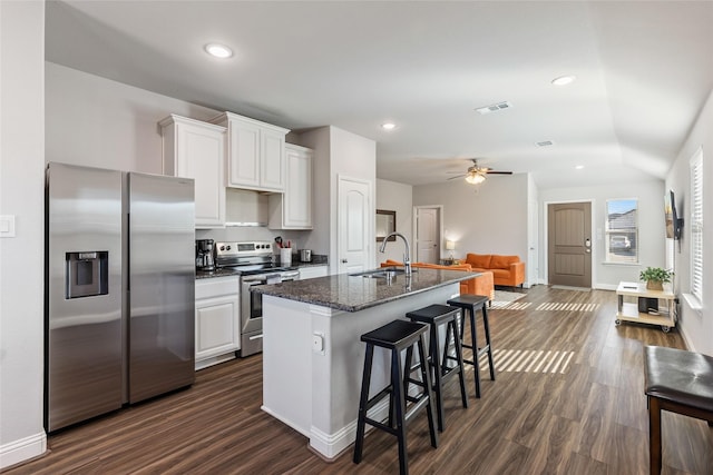 kitchen featuring a center island with sink, visible vents, appliances with stainless steel finishes, a breakfast bar, and a sink