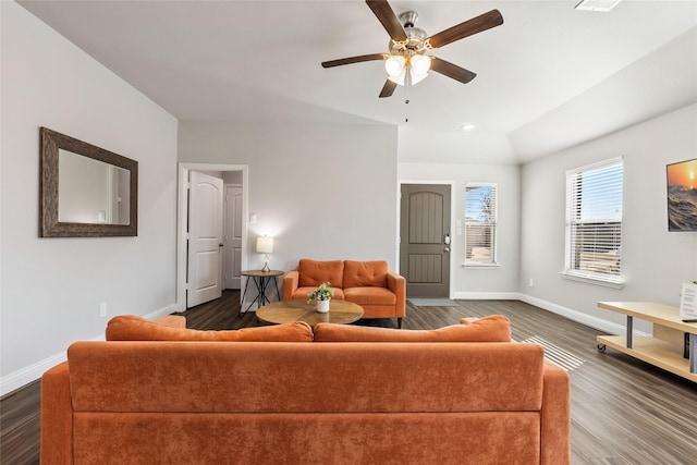 living area featuring lofted ceiling, dark wood-style flooring, and baseboards