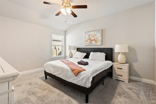 carpeted bedroom with vaulted ceiling, baseboards, and ceiling fan