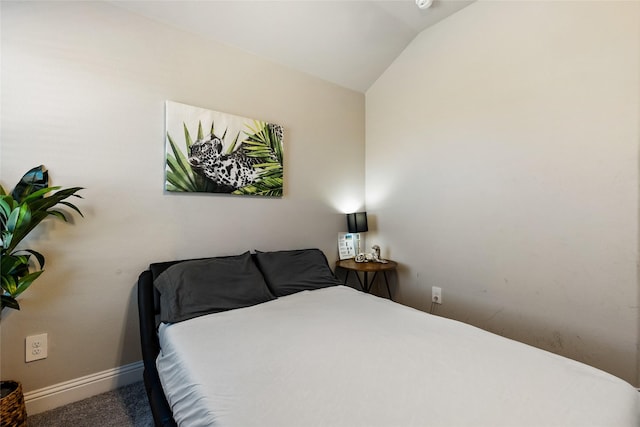 bedroom featuring lofted ceiling, baseboards, and carpet floors