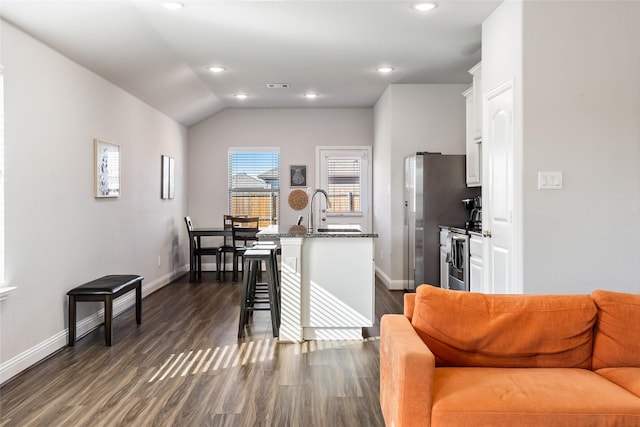 kitchen featuring a kitchen island with sink, dark wood-type flooring, a sink, white cabinetry, and stainless steel electric stove