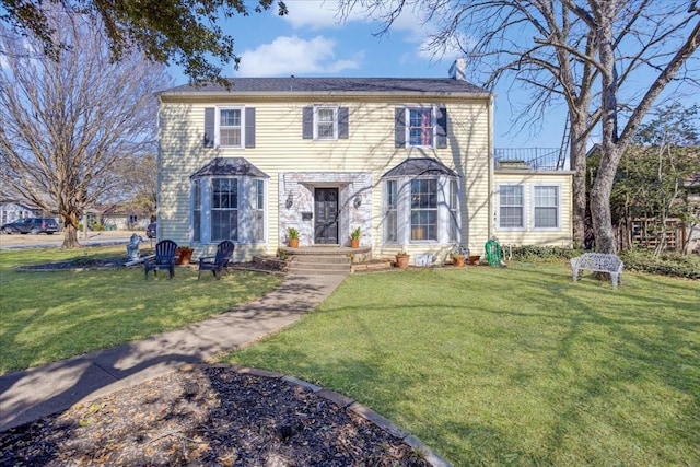 colonial house featuring a front lawn