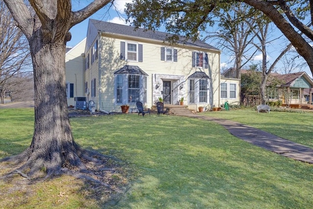 colonial home with central AC and a front yard