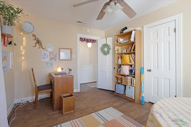 bedroom with ceiling fan, wood finished floors, visible vents, and baseboards