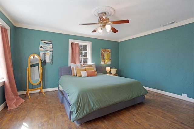 bedroom featuring baseboards, wood finished floors, and crown molding