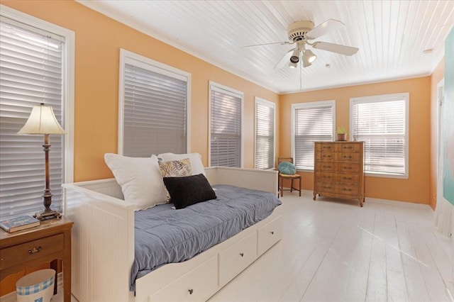 bedroom with light wood-style floors, ceiling fan, baseboards, and ornamental molding